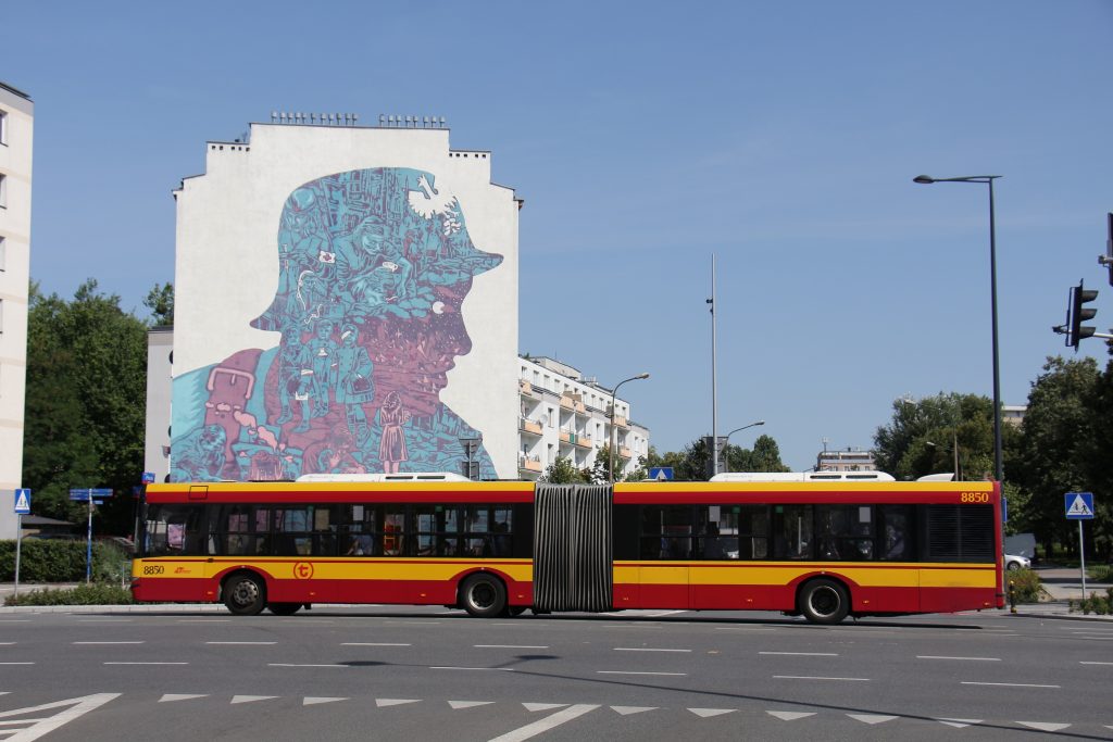 Autobus przegubowy na tle muralu powstańczego
